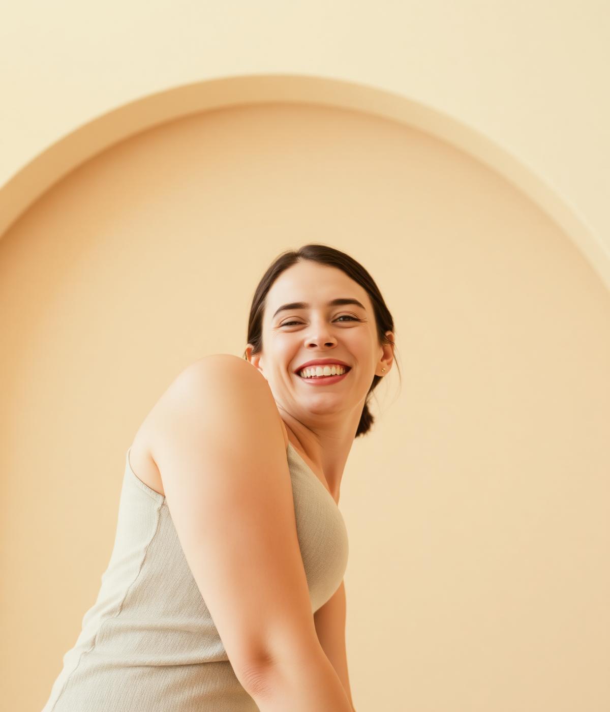 A smiling woman leaning forward in warm neutral light